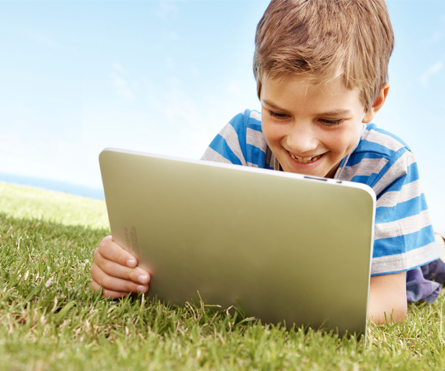 boy reading outside on tablet