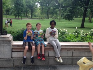 3 kids with books in Central Park