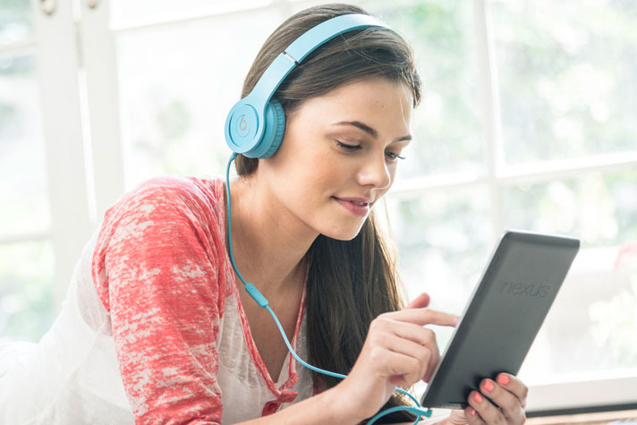 a student listening to audiobooks on her tablet