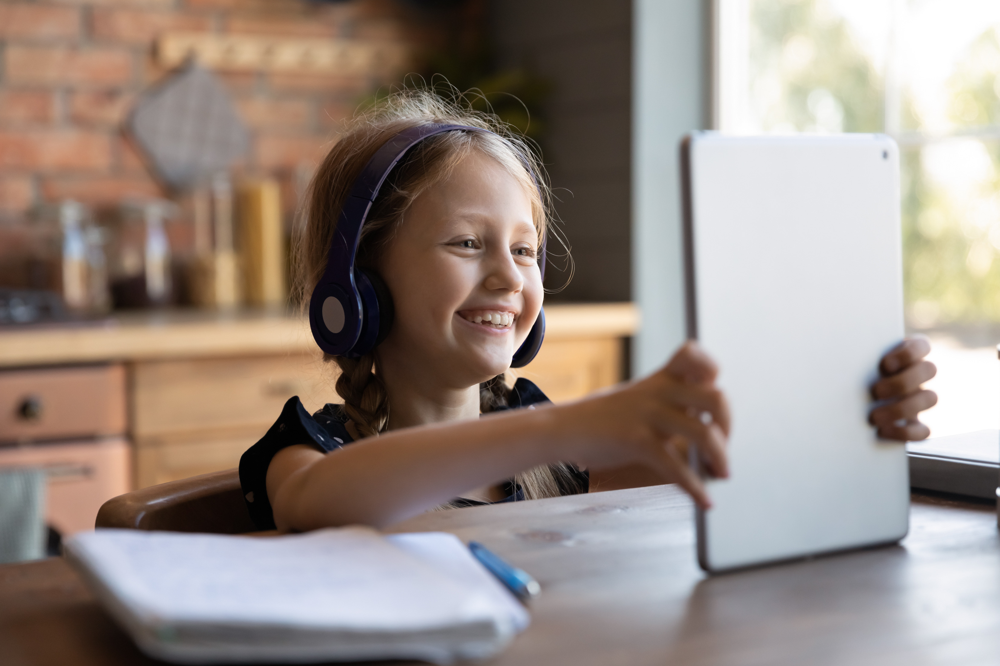 little girl headphones on laptop