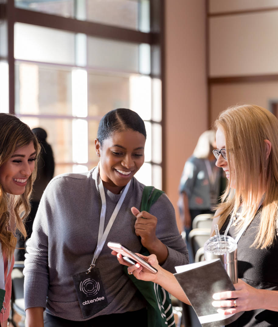 Three women looking at phone and laughing