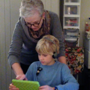 Connie helping a student reading on his tablet