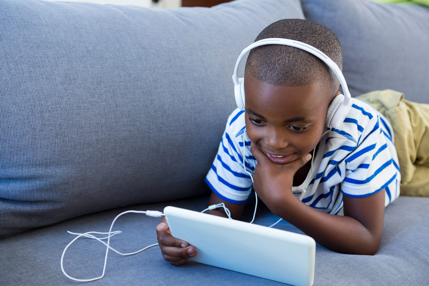 young boy listening to audio book on ipad